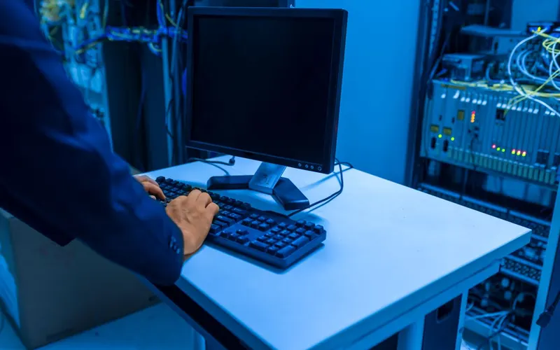Un técnico trabaja en una consola dentro de una sala de servidores